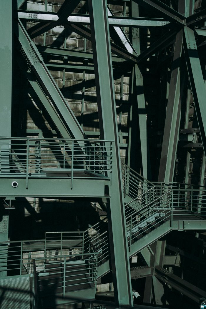 Close-up view of intricate industrial metal structures with stairs and railings.